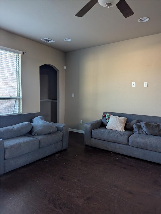 living room with ceiling fan and dark wood-type flooring