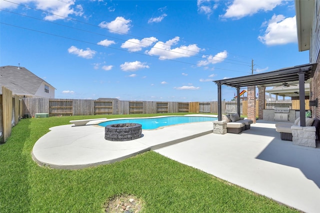 view of swimming pool featuring a lawn, a patio area, and exterior kitchen