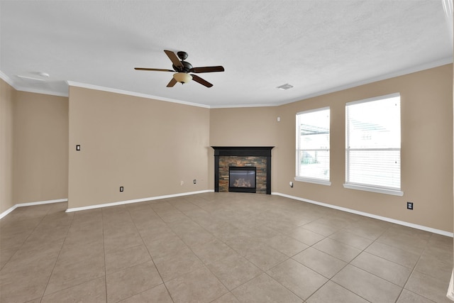 unfurnished living room with a stone fireplace, ceiling fan, light tile patterned floors, a textured ceiling, and ornamental molding