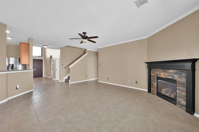 unfurnished living room featuring ceiling fan, a fireplace, light tile patterned flooring, and crown molding