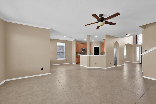 unfurnished living room featuring a wealth of natural light, ceiling fan, light tile patterned flooring, and ornamental molding