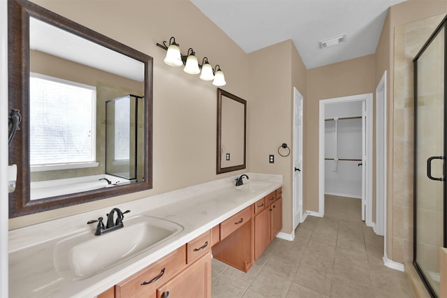 bathroom featuring tile patterned floors, vanity, and a shower with shower door