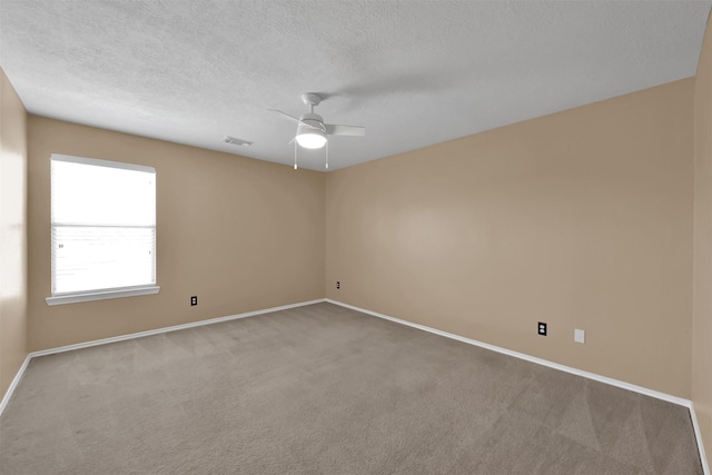 spare room featuring ceiling fan, carpet floors, and a textured ceiling