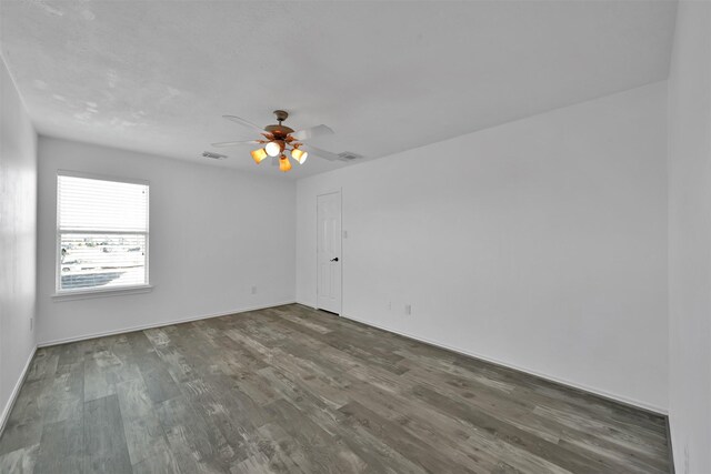 spare room with ceiling fan and dark wood-type flooring