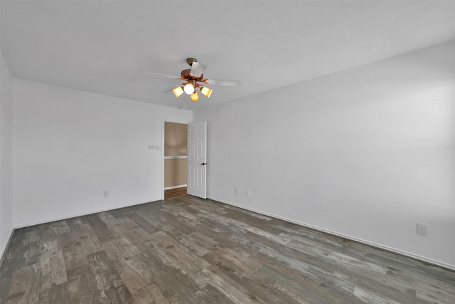 empty room featuring ceiling fan and dark wood-type flooring