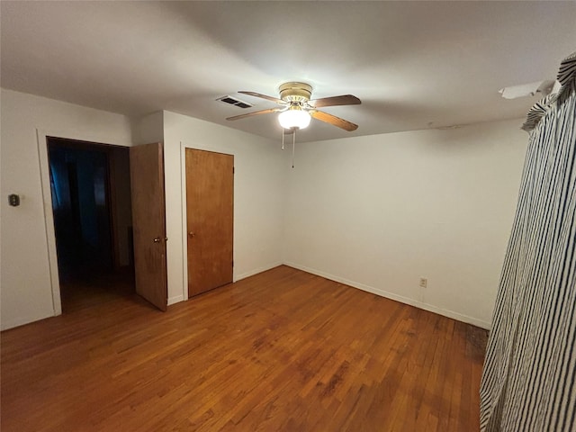 unfurnished bedroom with ceiling fan, wood-type flooring, and a closet