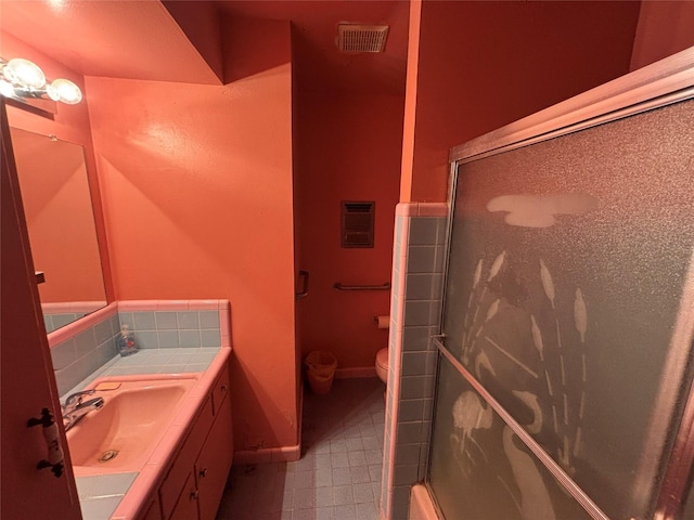 bathroom featuring toilet, vanity, and walk in shower