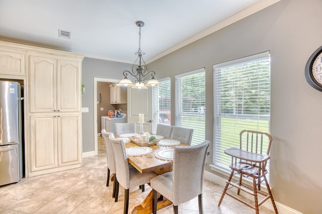 tiled dining area featuring crown molding and an inviting chandelier