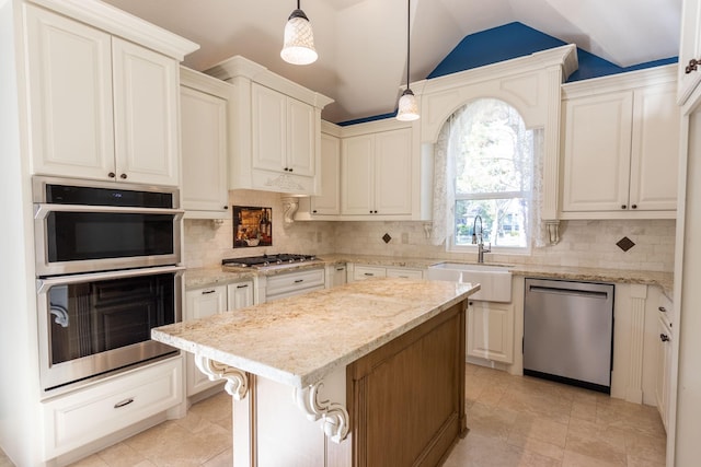 kitchen featuring appliances with stainless steel finishes, sink, decorative light fixtures, a center island, and lofted ceiling