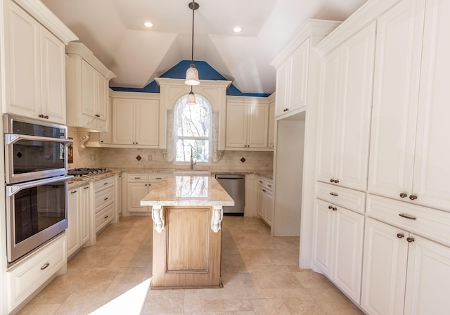 kitchen featuring backsplash, stainless steel appliances, vaulted ceiling, decorative light fixtures, and a center island