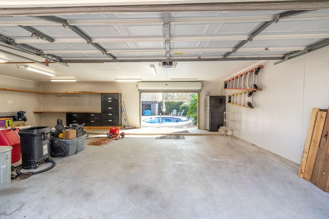 garage featuring stainless steel fridge and a garage door opener