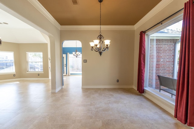 spare room featuring plenty of natural light, ornamental molding, and a notable chandelier