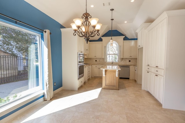 kitchen featuring decorative backsplash, appliances with stainless steel finishes, vaulted ceiling, decorative light fixtures, and a kitchen island