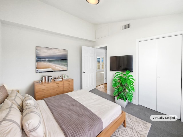 carpeted bedroom featuring lofted ceiling and a closet