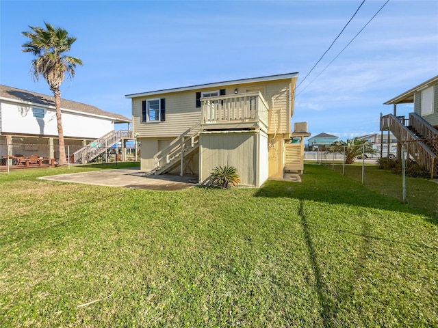 back of property featuring a yard, a patio, and a wooden deck