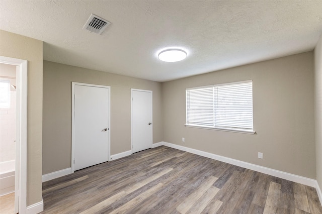 unfurnished bedroom with wood-type flooring and a textured ceiling