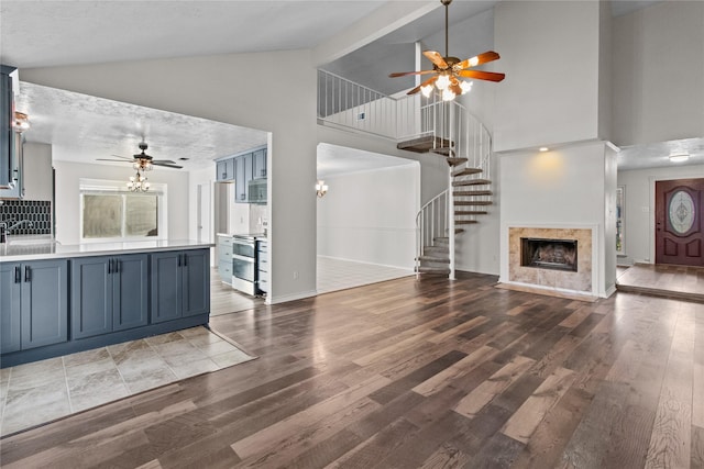 kitchen featuring a high end fireplace, wood-type flooring, blue cabinets, and appliances with stainless steel finishes