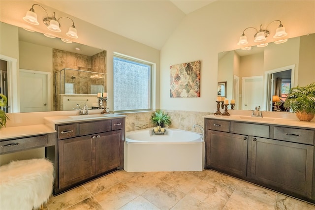 bathroom with vanity, independent shower and bath, and vaulted ceiling