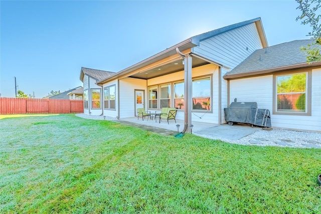 rear view of house with a lawn and a patio