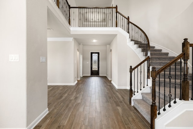 foyer entrance with a high ceiling and dark hardwood / wood-style flooring