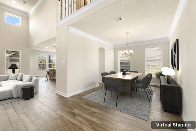 dining room with a notable chandelier, plenty of natural light, and crown molding