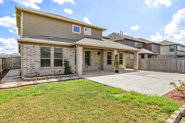 back of house featuring a patio and a lawn