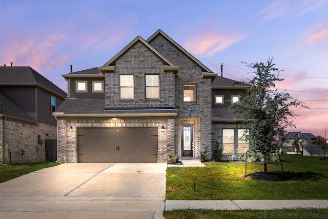 view of front of home with a yard and a garage