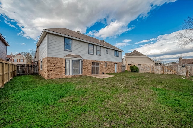 rear view of house with a yard and a patio