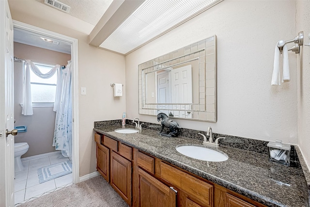 bathroom featuring tile patterned floors, vanity, and toilet