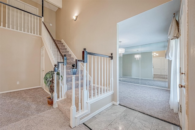 staircase with carpet and a notable chandelier