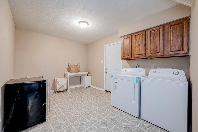 washroom featuring cabinets, independent washer and dryer, and a textured ceiling