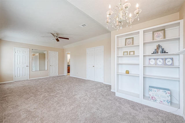 unfurnished bedroom featuring carpet flooring, ceiling fan with notable chandelier, and a textured ceiling