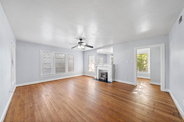 unfurnished living room with hardwood / wood-style floors, a textured ceiling, and ceiling fan