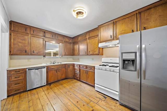 kitchen featuring sink, white appliances, and light wood-type flooring