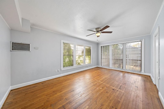 unfurnished room with a textured ceiling, hardwood / wood-style flooring, ceiling fan, and crown molding