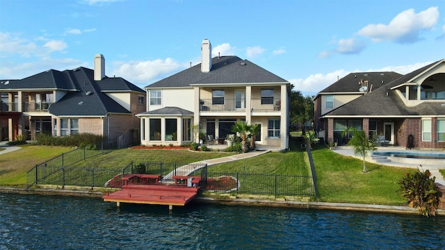 rear view of property with a water view and a yard