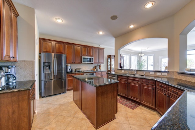 kitchen with backsplash, kitchen peninsula, a center island, and appliances with stainless steel finishes