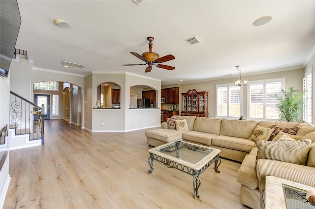 living room with crown molding, french doors, light hardwood / wood-style floors, and ceiling fan with notable chandelier