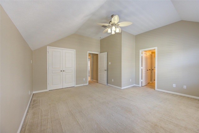 unfurnished bedroom featuring a closet, ceiling fan, lofted ceiling, and light colored carpet