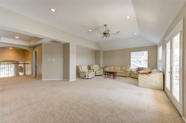 unfurnished living room with light carpet, vaulted ceiling, ceiling fan, and a healthy amount of sunlight