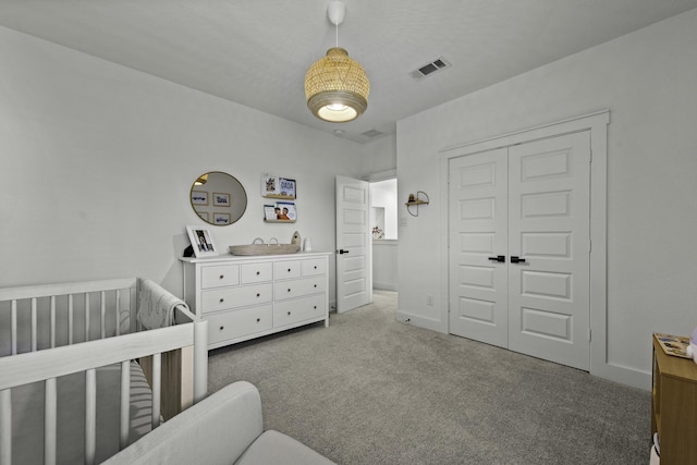 bedroom featuring a closet, carpet, and a nursery area