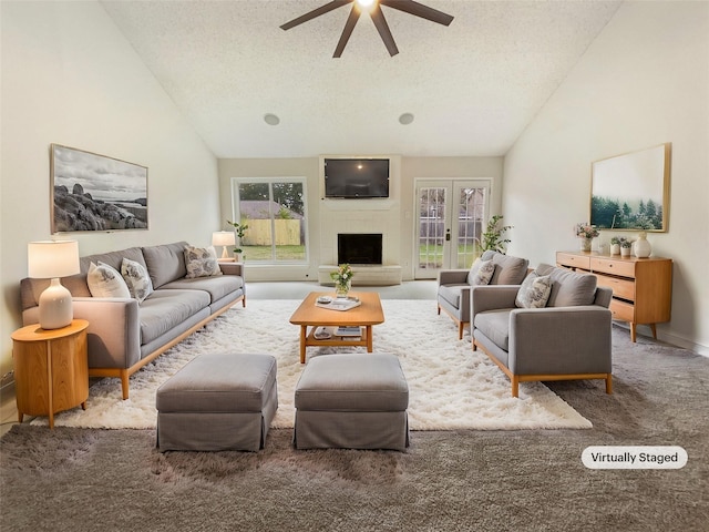 living room featuring ceiling fan, a large fireplace, plenty of natural light, and a textured ceiling