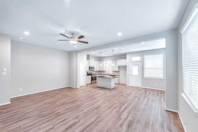 unfurnished living room with ceiling fan and light hardwood / wood-style floors