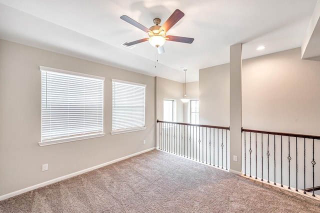 carpeted spare room featuring ceiling fan and a healthy amount of sunlight