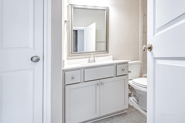 bathroom featuring tile patterned flooring, vanity, and toilet