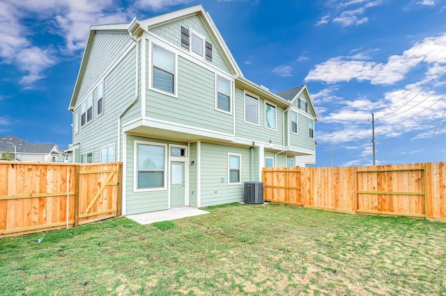 rear view of property featuring a yard and cooling unit