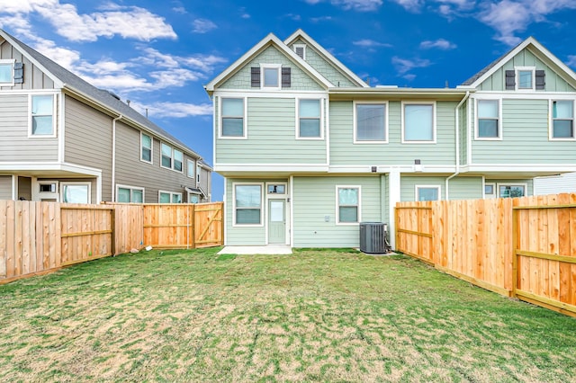 back of property with central AC unit and a lawn