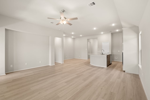 unfurnished living room featuring light hardwood / wood-style flooring, ceiling fan, and sink