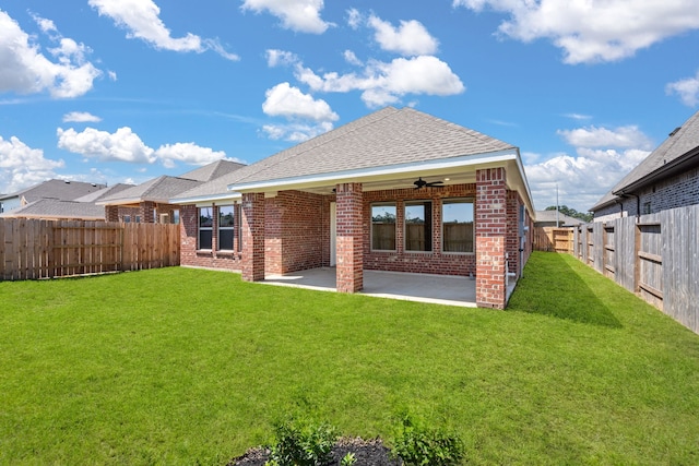 back of house featuring a lawn, ceiling fan, and a patio