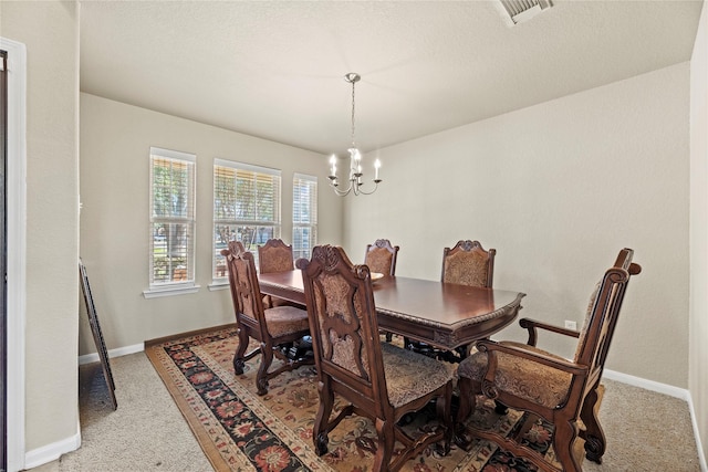 dining space featuring carpet and an inviting chandelier